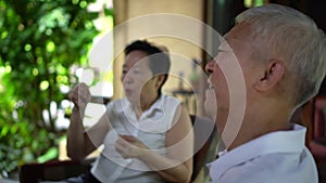 Eldery Asian couple have fun conversation hanging out with friends