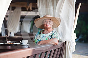 An eldery woman sitting in the coffe house.