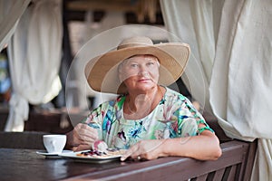 An eldery woman sitting in the restaurant.