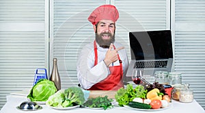 Elearning concept. Chef laptop read culinary recipes. Culinary school. Hipster in hat and apron learning how to cook
