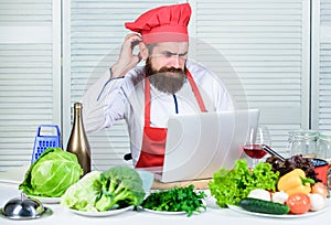 Elearning concept. Man chef searching internet recipe cooking food. Chef laptop read culinary recipes. Culinary school