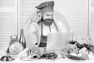 Elearning concept. Man chef searching internet recipe cooking food. Chef laptop read culinary recipes. Culinary school