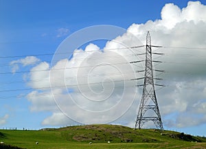 Electicity pylon on hillside.