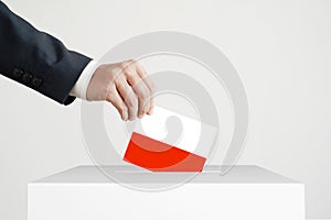 Election. Man putting a ballot with Polish flag into a voting box