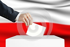 Election in Poland. Man putting a ballot into a voting box