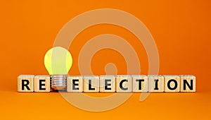 Election or reelection symbol. Cubes with words `Election reelection`. Yellow light bulb. Beautiful orange background. Business, photo