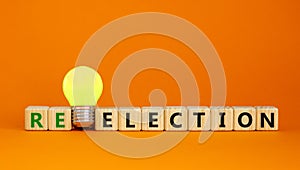 Election or reelection symbol. Cubes with words `Election reelection`. Yellow light bulb. Beautiful orange background. Business,