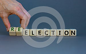 Election or reelection symbol. Wooden cubes with words `Election reelection`. Businessman hand. Beautiful grey background.