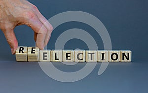 Election or reelection symbol. Wooden cubes with words `Election reelection`. Businessman hand. Beautiful grey background.