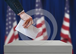 Election in United States of America. Voter holds envelope in hand above vote ballot.