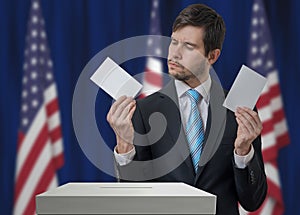 Election in USA. Undecided voter holds envelopes in hands above vote ballot.