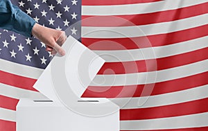 Elections, America. A human hand throws a ballot into the ballot box. American flag on the background. Election concept