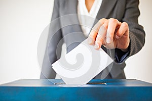 Elections - The hand of woman putting her vote in the ballot box