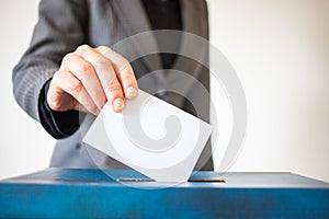 Elections - The hand of woman putting her vote in the ballot box