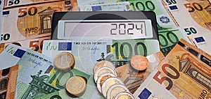 Elections and new challenges in 2024. Calculator on the background of 50 and 100 euro banknotes. Inflation, economic crisis