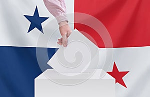 Elections, Panama. Voting concept. A hand throws a ballot into the ballot box. Panama flag on background