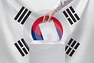 Elections, South Korea. A hand throws a ballot into the ballot box. The concept of democracy and freedom. The concept of voting