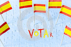 Elections in Spain, Spanish flag concept and VOTAR lettering meaning vote in English on white puzzle pieces photo