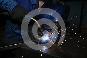 Electric arc welding. The worker welding two iron corners