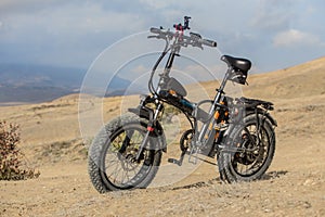 Electric Bicycle On A Hill On A Background Of Mountains