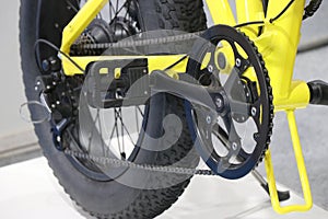 Electric bicycle with pedal option with close up view of chains and wheels. Yellow pedelec bikes