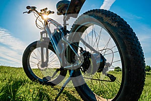 Electric bicycle with thick wheels in nature. Fatbike close-up