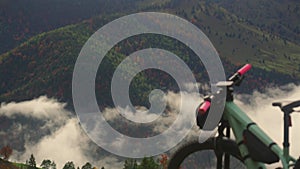 Electric bike stands on high mountain above clouds in autumn in Bavarian Alps. Brightly colored mountain e bike against