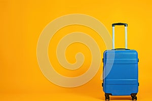 Electric blue suitcase rolling on yellow background