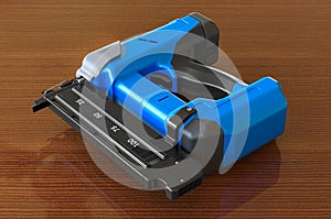 Electric Brad Nailer on the wooden table, 3D rendering