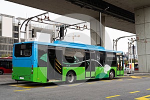 Electric bus at a stop is charged by pantograph. Clean mobility