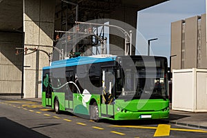 Electric bus at a stop is charged by pantograph. Clean mobility