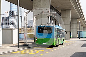 Electric bus at a stop is charged by pantograph. Clean mobility