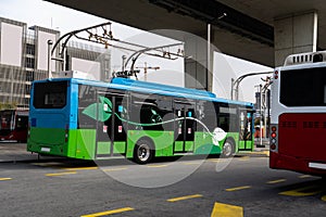 Electric bus at a stop is charged by pantograph. Clean mobility