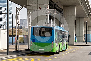 Electric bus at a stop is charged by pantograph. Clean mobility