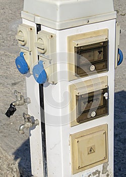 Electric cabinet with sockets and switches made with water taps in the public place. Danger. Electric shock risk and electrical