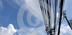 The electric cable cluttered in Thailand with blue sky background photo