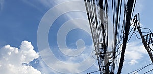 The electric cable cluttered in Thailand with blue sky background photo