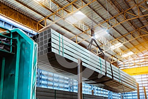 Electric Cable Hoist , heavy hoist iron hook lifting of Steel Pipes bunch and place on a truck at warehouse photo