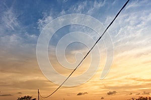 An electric cable with a panoramic background of a beautiful sunset against a yellowish blue sky in Cilacap Indonesia 13 Sept 20