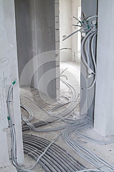 electric cables in corrugation stretching along the walls and floor and heating pipes radiating across the floor in a country