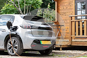 Electric car on charge at home green stripe on numberplate