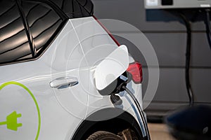 The electric car charger plugged in to the socket.The modern electric car charging the battery