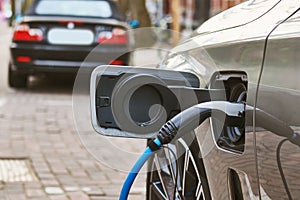 Electric Car Charging. Charger connector plugged to Electric auto