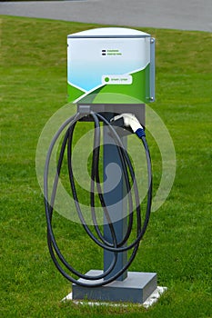 Electric car charging point installed on green lawn