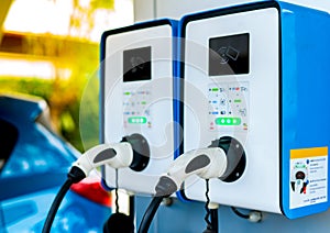 Electric car charging station. Plug for vehicle with electric motor. Coin-operated charging station. Clean energy power.