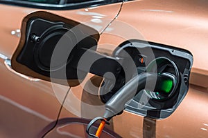 Electric car (EV) is charging in socket with cable