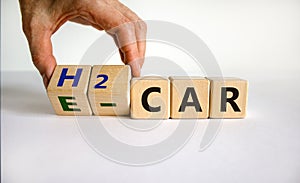 Electric car or a hydrogen car. Hand turns cubes and changes the expression `H2 car` to `E car` or vice versa. Beautiful white