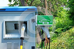 Electric cars charging concept. Green symbol on electric charging station. Ð¡harger for electric cars in park