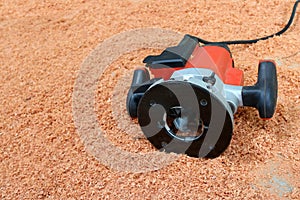 Electric circular routering saw on the sawdust background