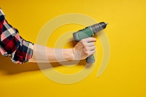 electric cordless screwdriver drill isolated on yellow background, professional home repair tool